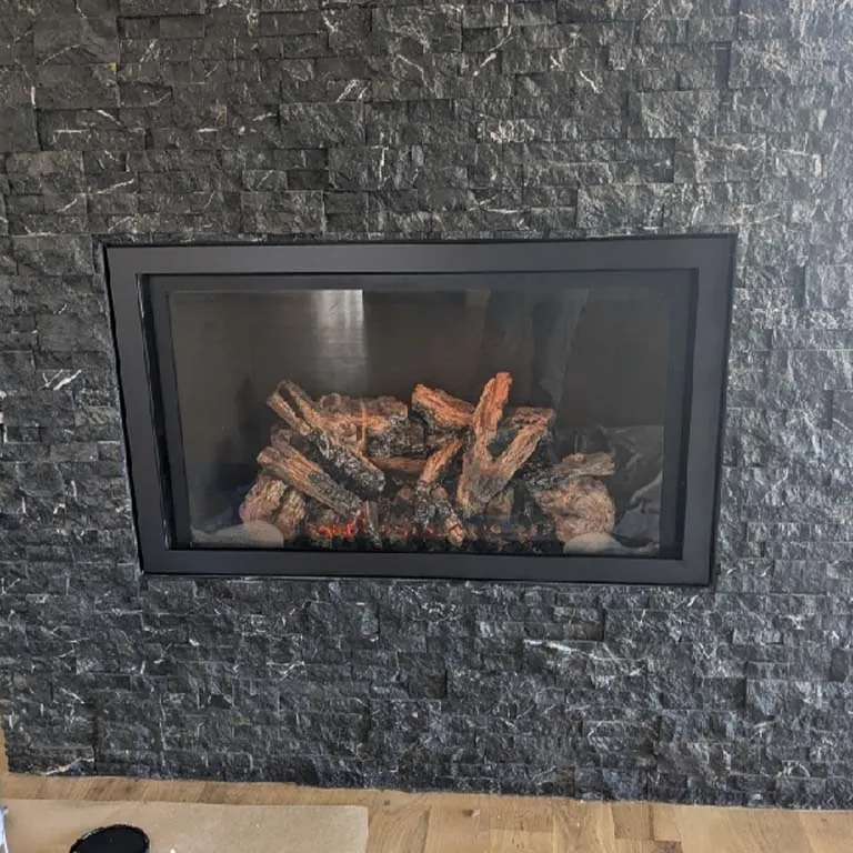 Black brick fireplace wall with clean gas insert